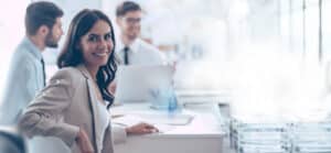 A female small business owner sitting a desk with two male colleagues