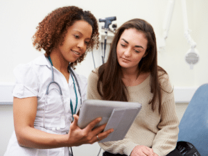 Healthcare professional showing information on a tablet to a patient