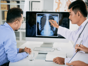 Doctor showing a patient an X-ray on a computer screen, highlighting the importance of comprehensive health insurance coverage